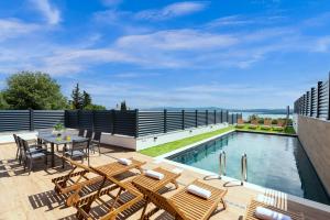 Un patio con mesa y sillas junto a una piscina. en Villa Faye, en Crikvenica