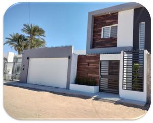 une maison avec deux portes de garage dans le sable dans l'établissement Casa Brianna Vacacional - Alberca Privada, à Puerto Peñasco