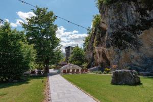 a park with benches and a rock wall at Pensiunea Apuseni Wild in Remeţi +46 photos
