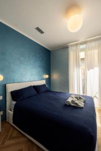 a bedroom with a bed with a blue wall at Casa Vèlo comodo bilocale elegante e di design in Turin