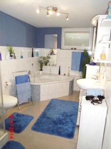a bathroom with a tub and a sink and a toilet and a bath tub at Ferienwohnung Vogesenblick in Mahlberg