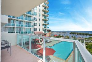 Un apartamento con balcón con piscina y vista al mar. en Fabulous 2 bedroom in Heart of Grove, en Miami