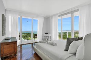 Una habitación blanca con una cama y ventanas y una mesa. en Fabulous 2 bedroom in Heart of Grove, en Miami 52 fotos más