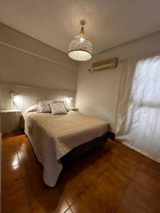 Un dormitorio con una cama y una lámpara de araña. en Encantador hogar en Tucumán, en San Miguel de Tucumán 10 fotos más