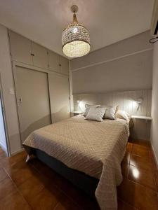 Un dormitorio con una cama y una lámpara de araña. en Encantador hogar en Tucumán, en San Miguel de Tucumán