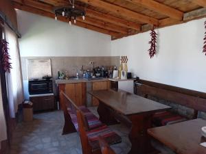 a kitchen with a wooden table and a stove at Поповата къща in Krapets