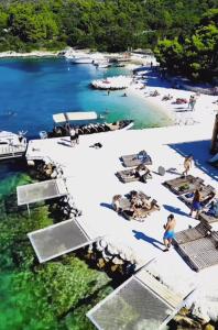 Una vista aérea de una playa con gente en el agua. en Comfort Lovely Apartment Diva 2, Čiovo, Okrug, en Trogir