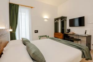 una camera d'albergo con un letto bianco e una scrivania di Cela Una Volta a Vieste