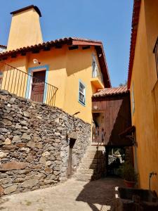 a building with a stone wall and a tower at Moinho do Granjão - Water Mill in Mesão Frio