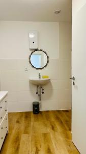ein Bad mit einem Waschbecken und einem Wandspiegel in der Unterkunft Mini Home Ferienwohnung - Monteurzimmer in Köln