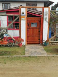 uma porta de madeira de uma casa com uma bicicleta na frente em La estancia en la Isla em Isla Negra