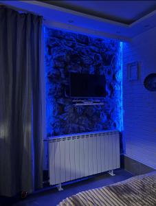 a room with a tv on a stone wall at Apartman Nina BANOVO BRDO in Belgrade +5 photos