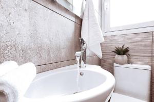 un bagno bianco con lavandino e WC di Penthouse - Amazing View in the Center of Athens ad Atene
