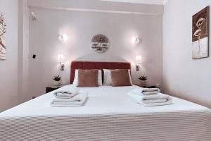 una camera da letto con un letto grande con asciugamani sopra di Penthouse - Amazing View in the Center of Athens ad Atene