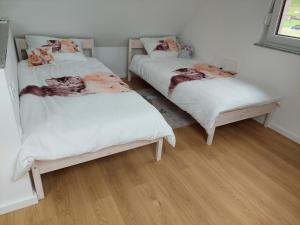 two twin beds in a room with wood floors at Apartment house Petra in Cerklje na Gorenjskem