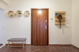 a wooden door in a room with a chair and books at Roubnb Acropolis Museum 1BD Apt in Athens