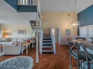 a living room with a couch and a staircase at The Water Bear in Topsail Beach