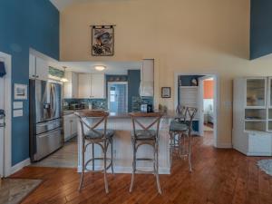 a kitchen with blue walls and bar stools at The Water Bear in Topsail Beach +44 photos