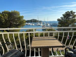 a wooden bench sitting on a balcony overlooking a marina at Apartments Mustel Drage - Adults Only in Drage