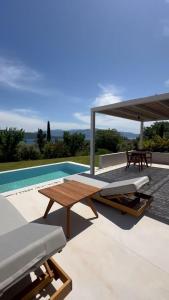 a patio with a picnic table and a pool at Cavalier Suites Nikiana Lefkada AV Properties in Nikiana