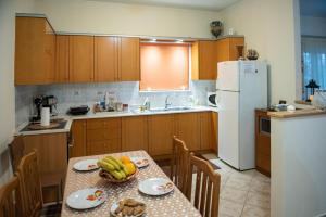 a kitchen with a table and a white refrigerator at Chrissoula House In Agioi Apostoloi in Daratso