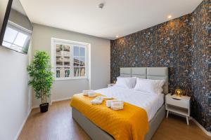 ein Schlafzimmer mit einem großen Bett mit einer gelben Decke in der Unterkunft BESTVILLAS Plaza in Braga