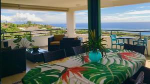 een balkon met een tafel en uitzicht op de oceaan bij Kaili Ocean view luxury 2BR AC throughout Fiber Wifi & Pool in Papeete