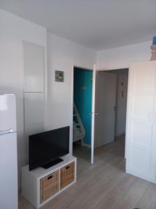 una sala de estar con TV de pantalla plana en un armario en Studio cabine Stella Plage, en Cucq