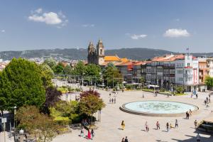 eine Gruppe von Menschen, die durch eine Stadt laufen in der Unterkunft BESTVILLAS Plaza in Braga