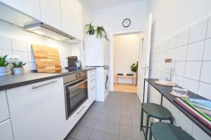 a kitchen with white appliances and green chairs at Live in the heart of Hamburg. in Hamburg +16 photos
