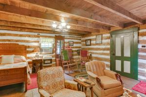 a room with a bed and chairs in a room with wooden walls at Ferrum Rustic Cabin in the Valley with Fire Pit in Ferrum