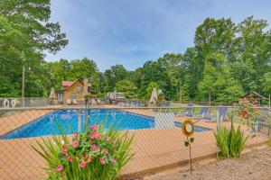 a fence with flowers in front of a swimming pool at Ferrum Rustic Cabin in the Valley with Fire Pit in Ferrum
