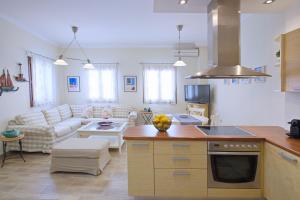 a kitchen and living room with a couch and a table at Amaryllis House Lefkada in Lefkada