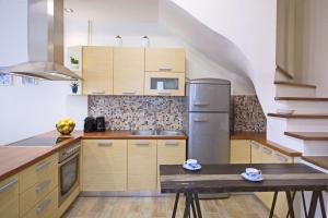 a kitchen with wooden cabinets and a stainless steel refrigerator at Amaryllis House Lefkada in Lefkada +21 photos