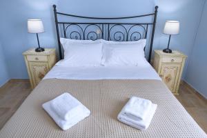 a bed with two towels on it with two night stands at Amaryllis House Lefkada in Lefkada