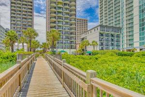 a wooden boardwalk in a city with tall buildings at Oceanfront Condo with Balcony in Myrtle Beach! in Myrtle Beach