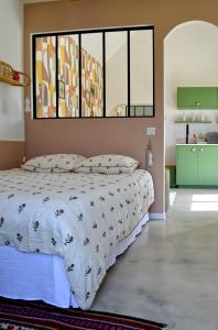 a bedroom with a bed and a large window at La petite maison de Celestine in Plonéour-Lanvern