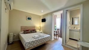 - une petite chambre avec un lit et une salle de bains dans l'établissement Residencial Duque de Saldanha, à Lisbonne