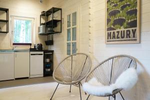 two chairs with white cushions sitting in a kitchen at Sosnowa Odnowa - domek na Mazurach z sauną i balią in Rybno