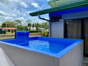 a plunge pool in a house with a blue top at Cabinas Arenal Home in Tanque