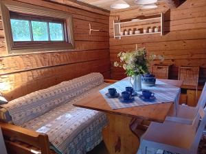 a room with a table and a couch in a cabin at Bobackan pihatorpan aitat in Hämeenlinna