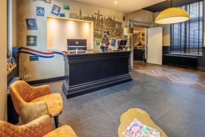 a waiting room with a counter and chairs and a laptop at Grand Hotel Alkmaar in Alkmaar