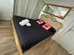 a bed with two pillows and a mirror at Atena B&B APARTMENTS Platino in San Silvestro