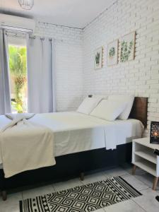 um quarto branco com uma cama grande e uma janela em Yabás Praia em Ubatuba