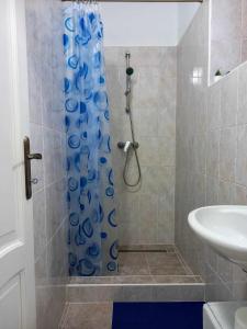 a bathroom with a shower with a blue shower curtain at Bike&Night in Baracska