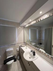une salle de bain avec un lavabo, des toilettes et un miroir dans l'établissement 201 Apartment-A perfect escape, à Paphos