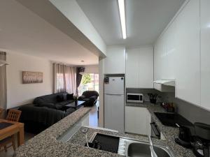 une cuisine avec un évier et un salon dans l'établissement 201 Apartment-A perfect escape, à Paphos