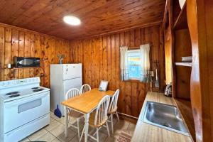 una cucina con un tavolo e un frigorifero bianco di 8 cottages on the beach of Lake Huron a Lincoln Junction