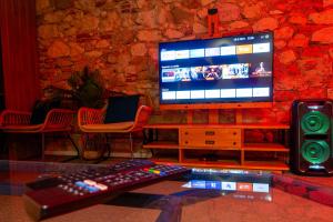 a room with a television and a keyboard and a speaker at Prestige De Cocagne in Lavaur