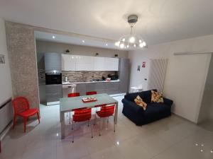 a kitchen and living room with a table and a couch at Piazzimmacolata53 in Molfetta